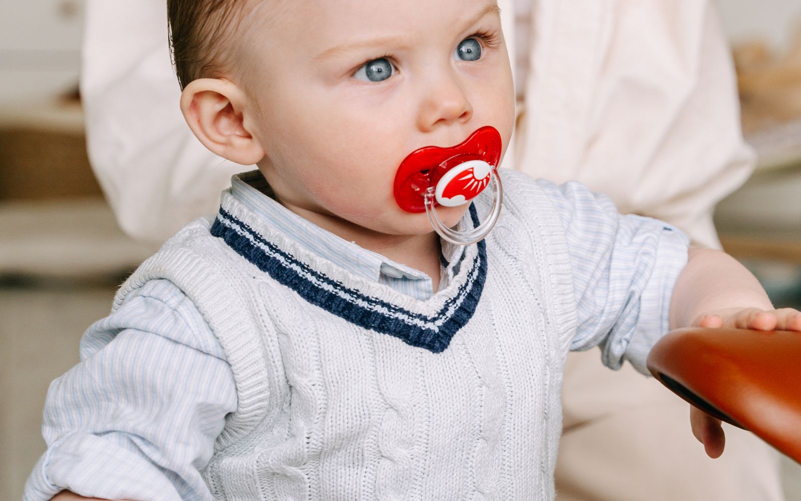 Bebê brincando com chupeta na boca