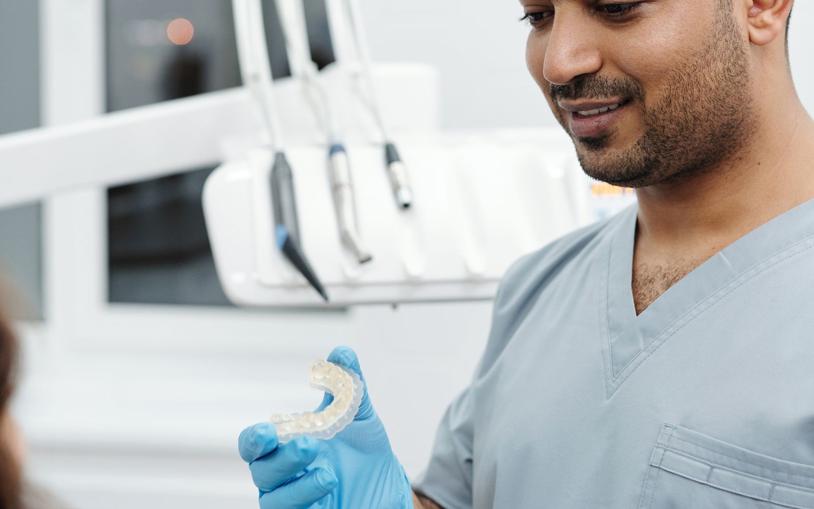 Dentista mostrando um alinhador transparente a uma paciente